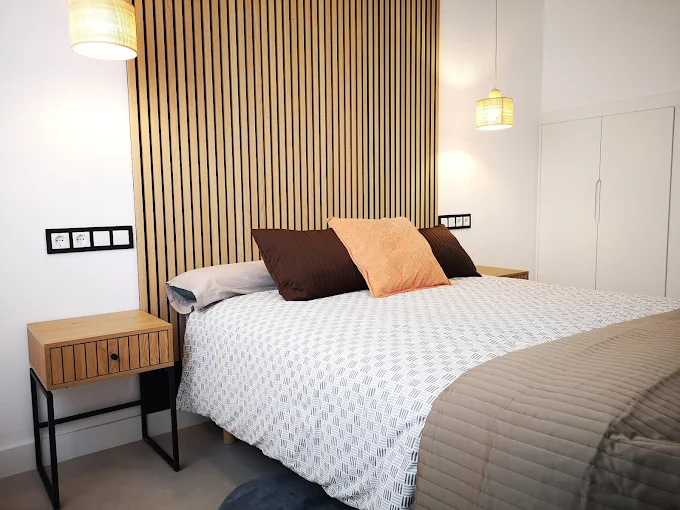 Dormitorio acogedor con cama, decoración moderna y ventana con cortinas ligeras.