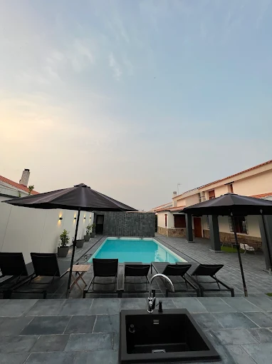 Terraza con piscina y mobiliario exterior, vista panorámica y decoración sostenible.