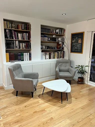 Despacho en casa con escritorio minimalista, silla ergonómica y luz natural.