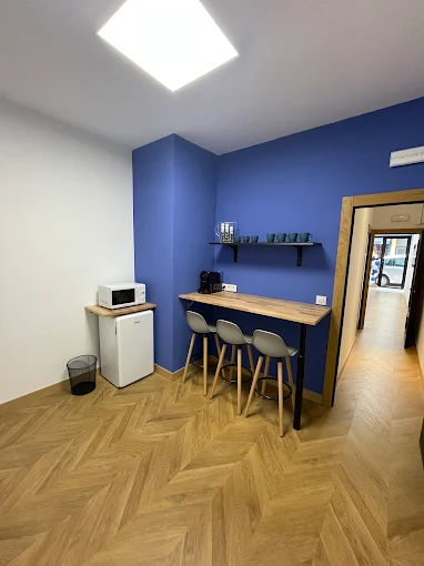 Pasillo con suelo de madera y paredes decoradas con cuadros modernos, iluminación tenue.