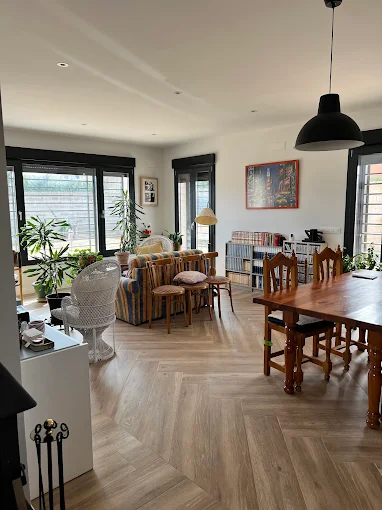 Salón moderno y luminoso con suelo de madera y diseño elegante, reforma integral con eficiencia energética.